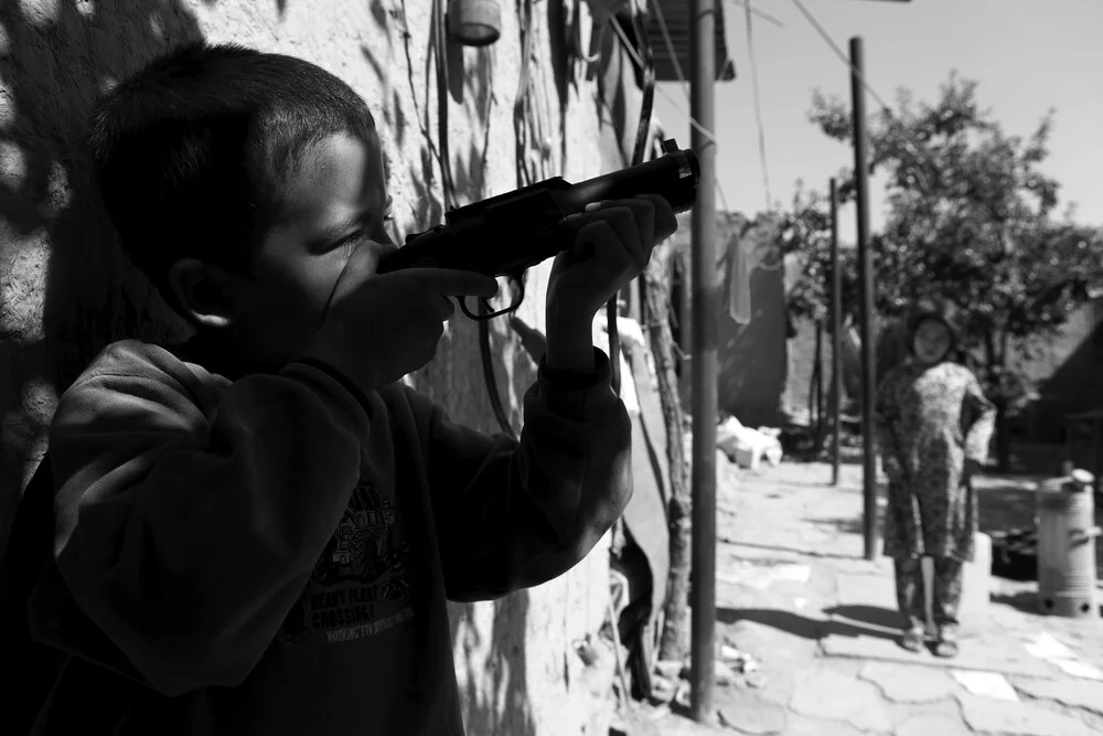 El niño con la pistola - Fotografía artística de Rada Akbar