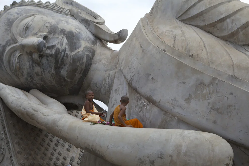 Monjes sentados en la gran estatua de Buda, Laos - Fotografía artística de Christina Feldt
