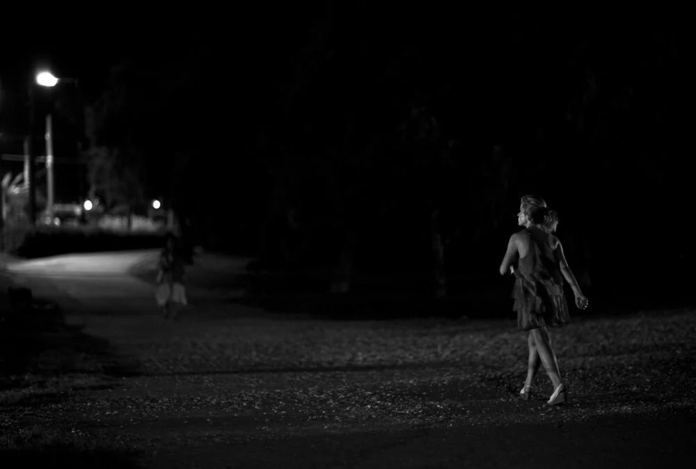 Une femme marchant dans le noir - Photographie fineart de Nasos Zovoilis