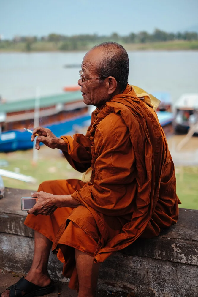 Moine au Cambodge en train de fumer - Photographie fineart par Jim Delcid
