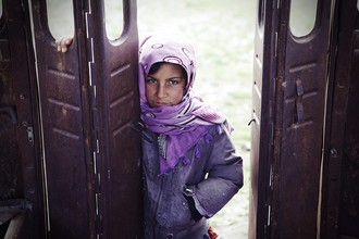 Rada Akbar, fille se tient à l'extérieur du bus en ruine (Afghanistan, Asie)