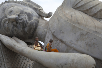 Christina Feldt, Moines assis sur la grande statue de Bouddha, Laos (Laos, Asie)