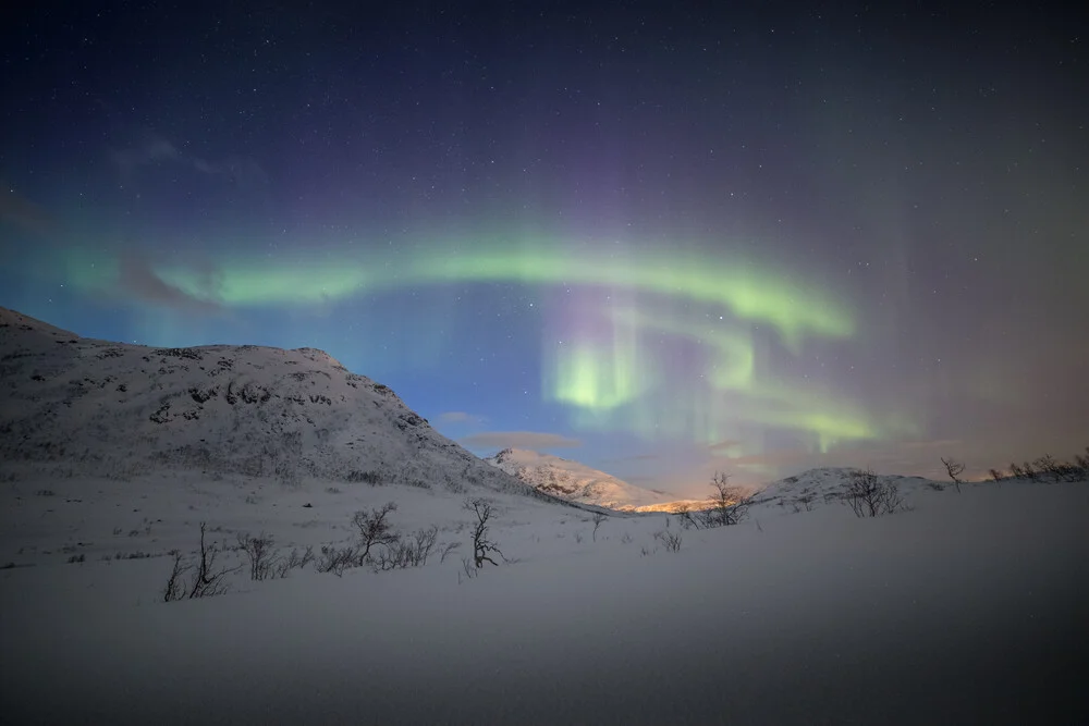 Fotokunst von Sebastian Worm: winterliche Szene mit schneebedeckten Bergen und Polarlichtern