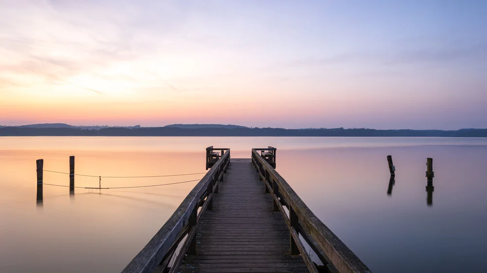 Ruhe am See: Sonnenaufgang über dem Wasser mit sanften Farben