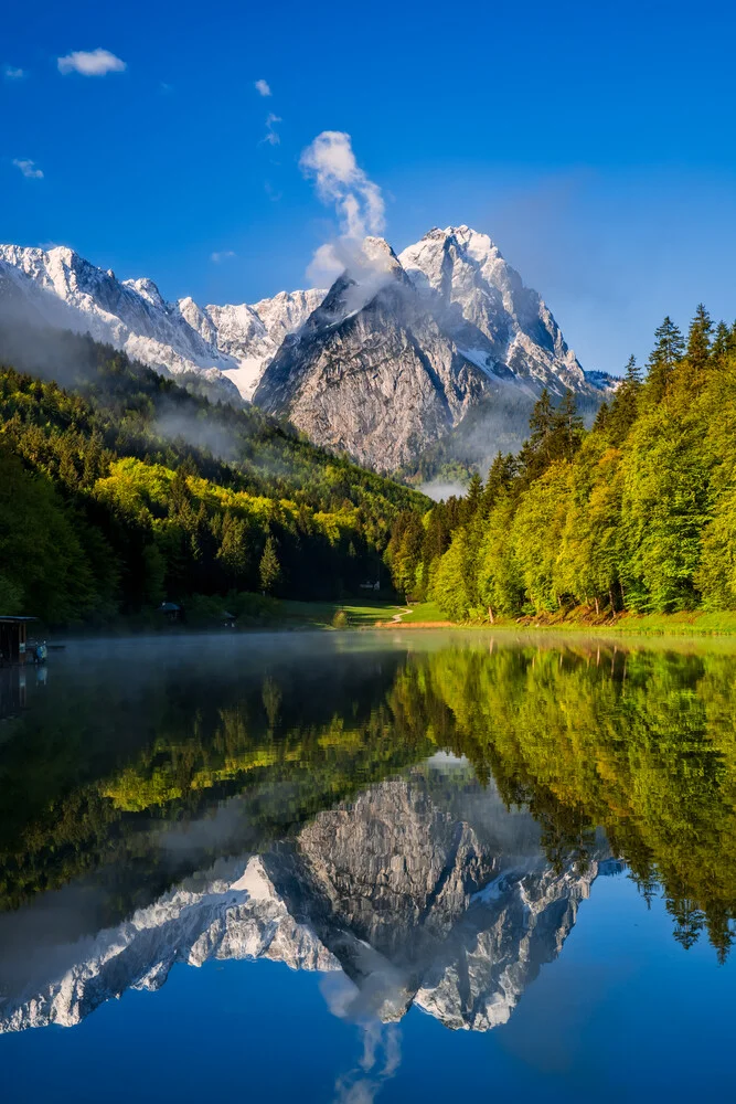 Panoramic view of the Bavarian Alps with gentle mountains and a calm water surface