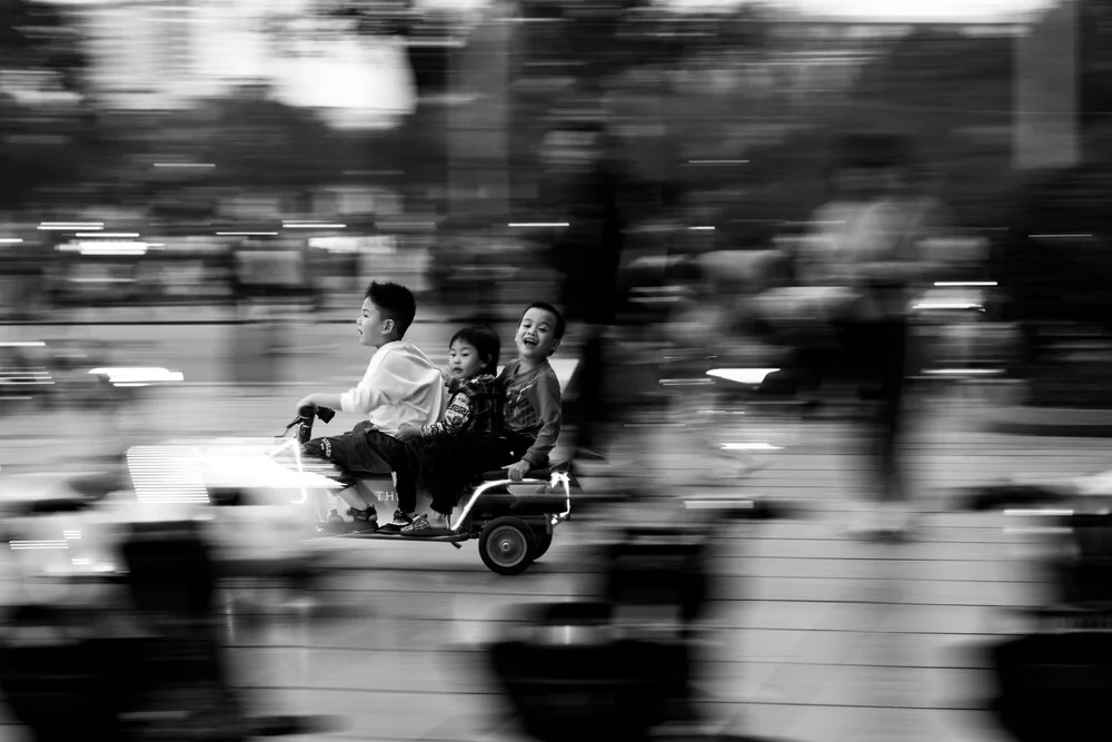 Fotokunst von Christian Seidenberg: Kinder voller Freude in einer belebten Straße in Hanoi