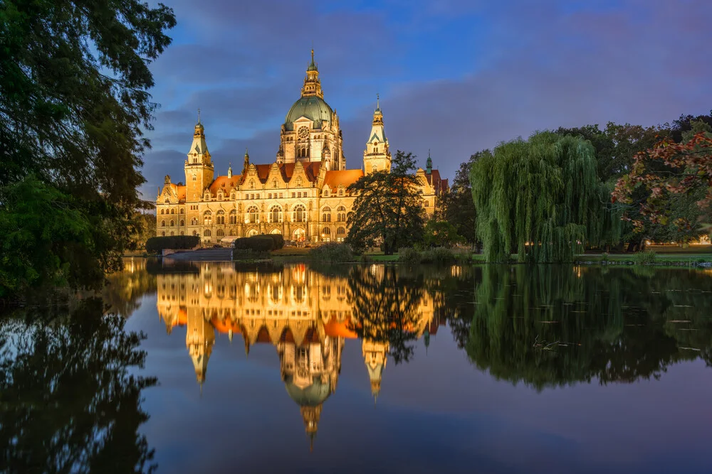Evening atmosphere at the New Town Hall in Hanover with soft lights and a calm pond