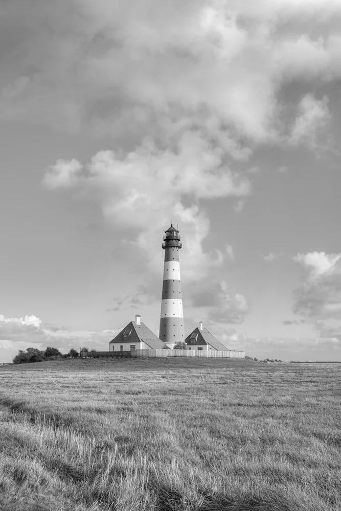 Black and white photo art: Westerheversand lighthouse by the North Sea with wide meadows