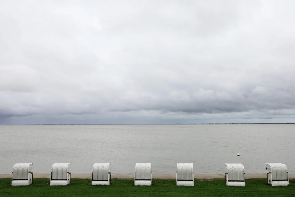 Waiting for summer: beach chairs by the sea under a cloudy sky