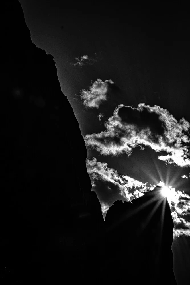 Black and white photo art: sun over the rocks of Meteora in Greece