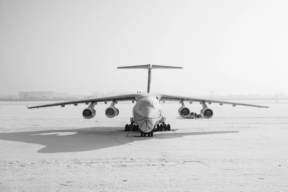 Fotokunst von Inflight Galerie: Antonov An125 über schneebedecktem Terrain in Schwarz-Weiß.