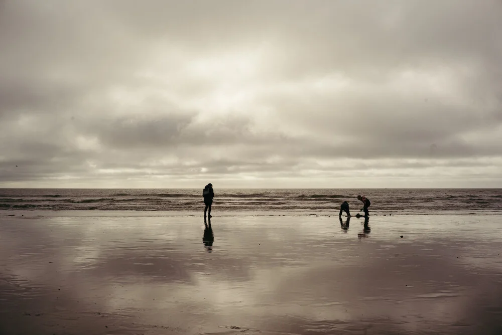 Minimalist silhouette of a family on a beach in Denmark, calm mood.