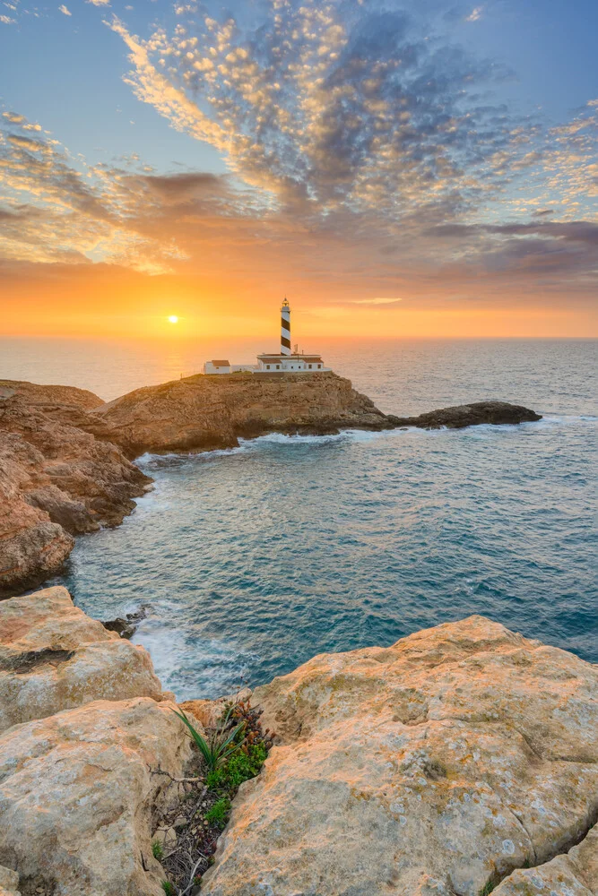 Sunrise at Faro de Cala Figuera in Mallorca with calm sea and clear sky
