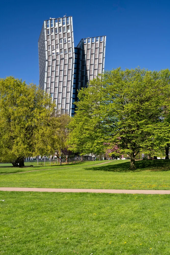 Photo art: View of Hamburg's dancing towers in spring, surrounded by green trees.