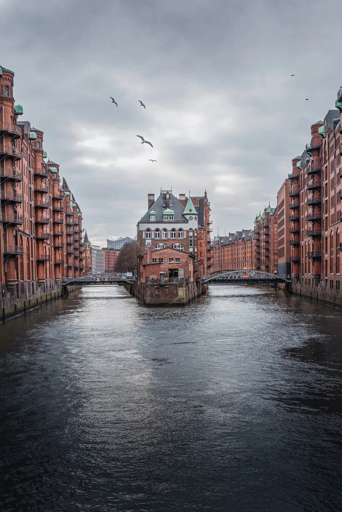 Fotokunst von Björn Witt: Wasserschloss in Hamburg mit ruhigem Wasser und urbanem Charme.