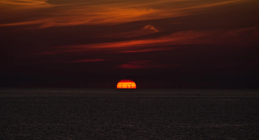 Photo art by Andreas Weiser: sunset over wind turbines, calming atmosphere.