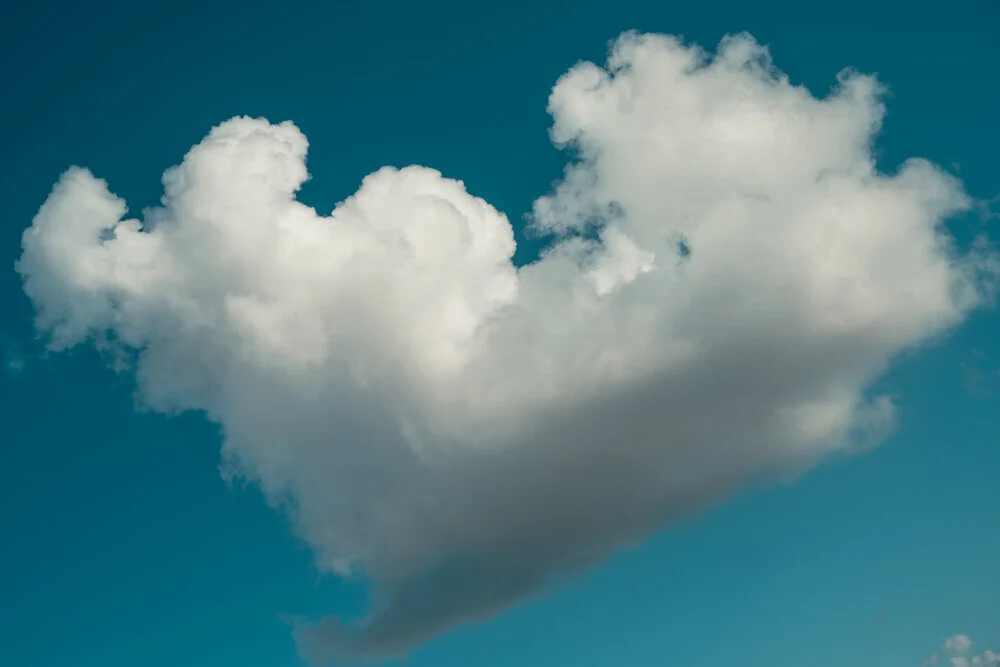 Wolke in Herzform am blauen Himmel, sanfte und liebevolle Stimmung.