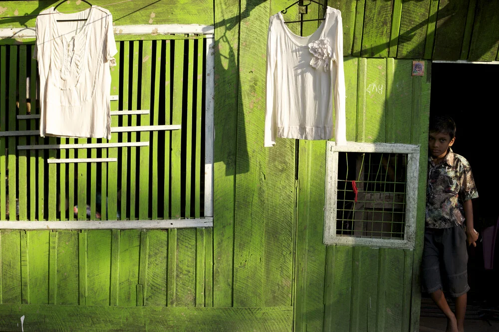 Boy in front of green house, Myanmar. - fotokunst von Christina Feldt