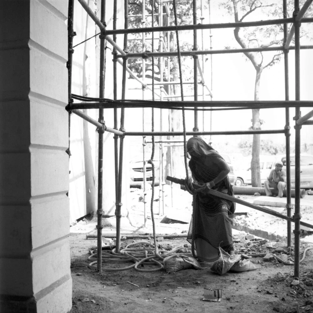 Eine Frau im Sari arbeitet auf einer Baustelle in Neu Delhi. - Fineart photography by Shantala Fels