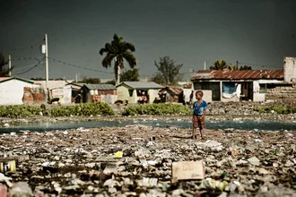 Photo art by Frank Domahs: Boy playing in a poor neighborhood of Port-au-Prince.