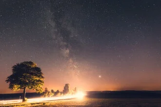 Milky Way over a country road, peaceful night scene filled with stars.