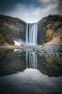 Fotokunst eines Wasserfalls in Island, sanfte Farben und ruhige Spiegelungen im Wasser.