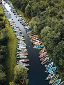 Wasserfahrzeuge am Ufer eines ruhigen Flusses in Irland
