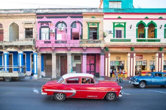 Red vintage car on a street in Havana, exuding a retro atmosphere.
