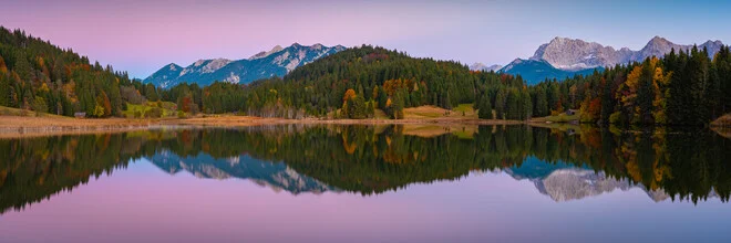 Panoramablick auf einen Bergsee mit herbstlichen Farben und ruhigem Wasser