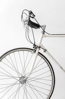 Minimalist photo of a white bicycle against a light background.