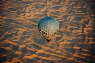 Helle Fotokunst eines Heißluftballons im Sonnenaufgang über der Wüste