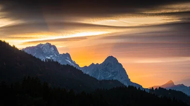 Sunset over the Bavarian Alps with soft colors in the sky.