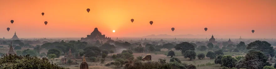 Colorful hot air balloons float over the city of Bagan at sunrise.