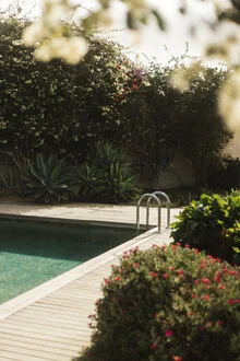 Colorful backyard with sunlight and pool in Spain, creating a relaxing vacation atmosphere
