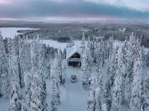 Photo art by André Alexander: a house in a snowy winter forest in Finland