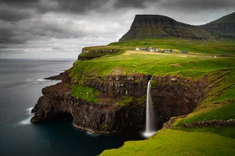 Beautiful waterfall in Gasadalur, surrounded by green hills and a serene mood.