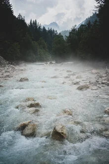 Light blue river surrounded by trees and gentle waves in nature.
