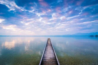 Morning light at Chiemsee with calm water and soft mountains in the background