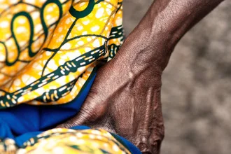 Woman singing in Asotwe village, joyful mood with traditional music.