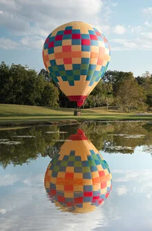 Colorful balloons floating over a serene landscape in China.