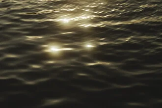 Minimalistic water surface with sparkling light at sunset