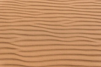 Muster aus Sanddünen in der Wüste mit sanften Linien und Schatten