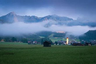 Morning view of the mountains in Heiterwang, gentle fog surrounds the peaks.