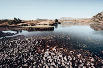 Photo art by Eva Stadler: serene mountain lake surrounded by majestic peaks