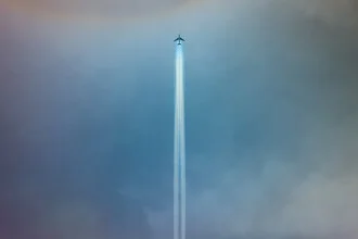 Photo art by Roman Becker: Airliner leaves contrasting contrails in a blue sky