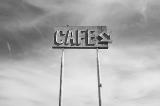 Photo art featuring a café sign against a clear sky in a minimalist composition.