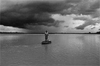 Fotokunst von Sankar Sarkar: Fischer auf einem ruhigen Fluss in Indien