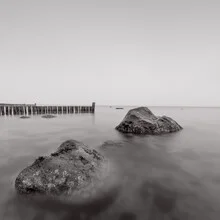 Photo art by Dennis Wehrmann: calm Baltic Sea with gentle waves and stones on the shore.