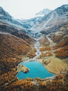 Heart-shaped lake in the Alps, surrounded by colorful autumn trees and mountains