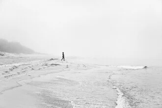 Woman at the beach, surrounded by mysterious fog and gentle sea waves